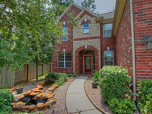 Low maintenance landscaping and pond accentuate the front entrance