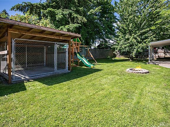 Covered dog kennel, fire pit with 2 patio areas. Swing set and trampoline do NOT stay.
