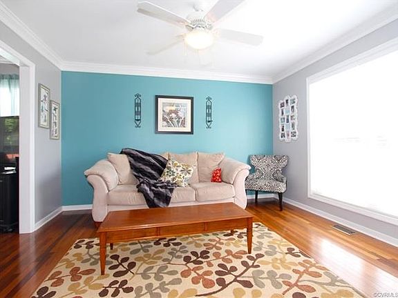 The Formal Living Room features a Lighted Ceiling Fan, Brazilian Walnut Hardwood and Double Windows providing a light and airy ambiance.