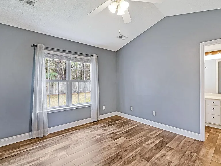 Master bedroom with vaulted ceilings. Master split bathroom ahead.