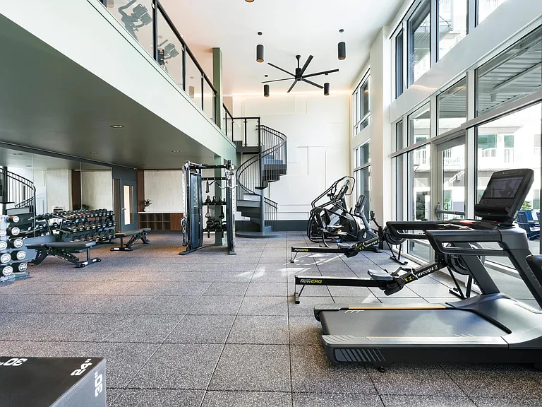 Elevate your workout in our two-level fitness center, where floor-to-ceiling windows flood the space with natural light.