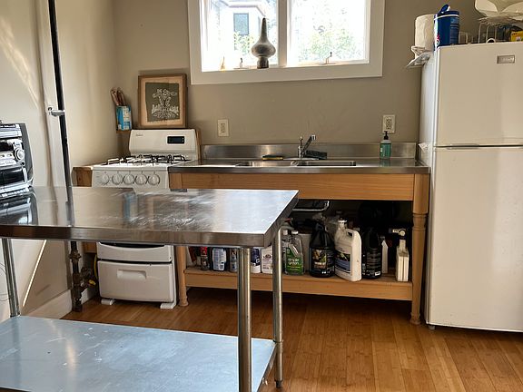 kitchen with antique stainless counter and sink, long-neck faucet,
 stainless counter and shelf