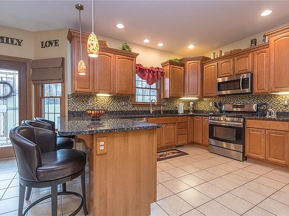 Chic pendent lighting and staggered cabinet heights (with up & under lighting) lend style to the room while a hi profile touch f