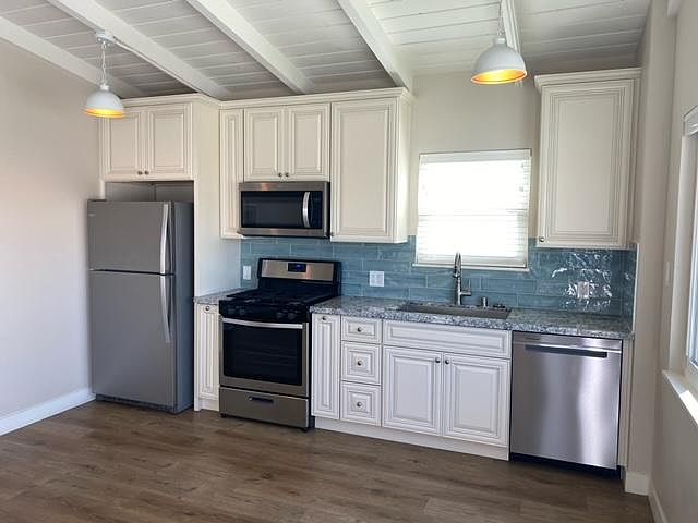 The kitchen area of the open concept living and kitchen. Refrigerator, stove, microwave, and dishwasher included.