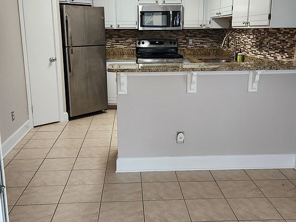 Kitchen all stainless appliances including dishwasher not seen.