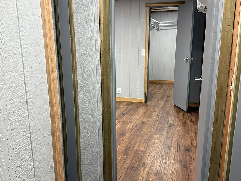 Hallway to back porch has an open coat closet and entry to master bedroom.