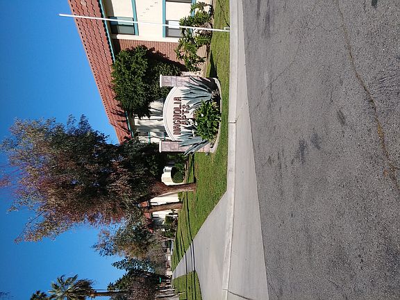 Mature trees and landscaping in front of Magnolia Apartments in Riverside, California.