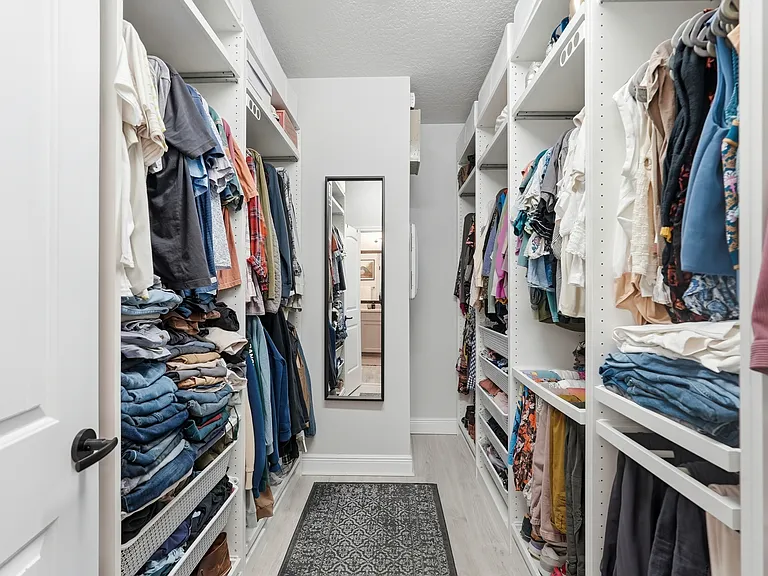 Primary over-sized walk--in closet with built-in storage to floor-to-ceiling