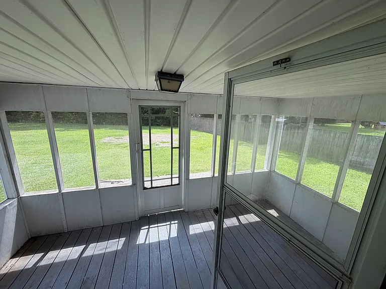 screened in back porch with concrete patio outside