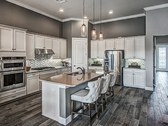Model Representation Gourmet kitchen with stainless gas appliances and large center island