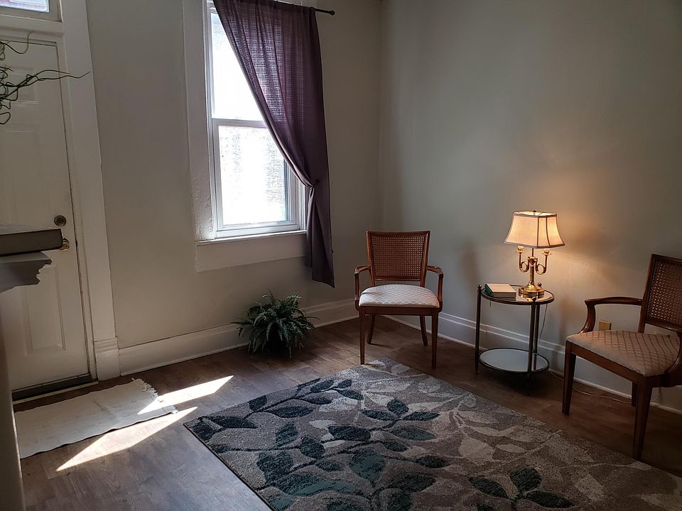 Livingroom with chairs opposite the mantle.
