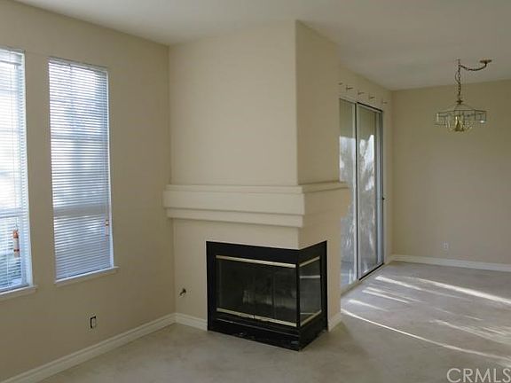 living room with a gas fireplace and dining area under chand