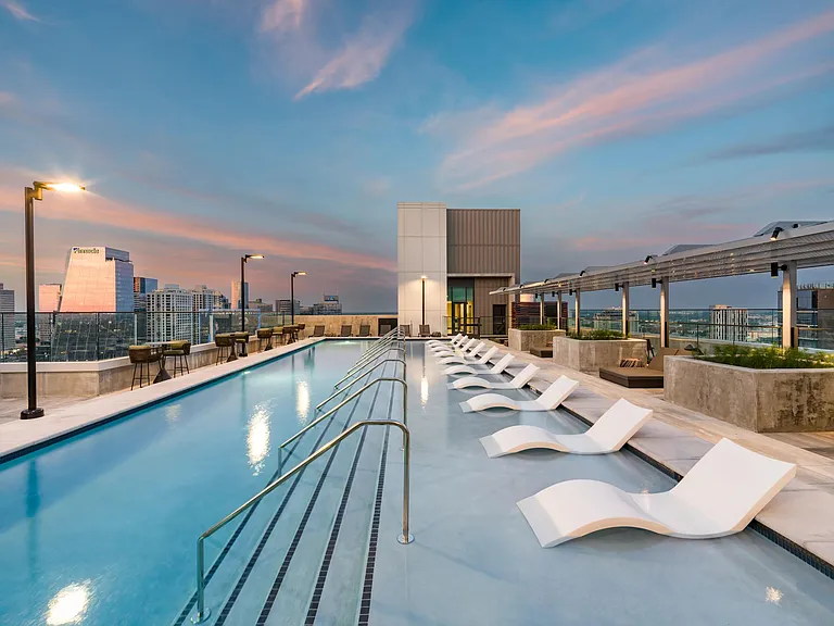 Rooftop pool with skyline views, streamlined loungers, and sunset backdrops designed for unwinding, social time, and evening swims.