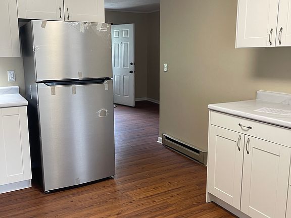 DOORWAY TO ENTER THE KITCHEN WITH BRAND NEW FRIDGE AND SOFT-CLOSE CUPBOARDS. NOTICE THE NEW FLOORS AND FRESH PAINT.