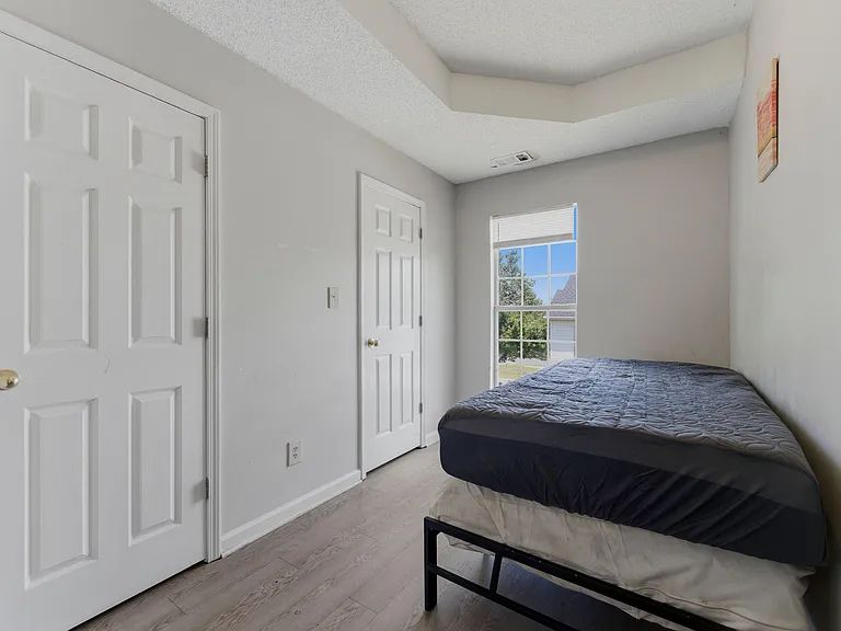 Private bedroom with a window for natural light, neutral finishes, and convenient closet and room entry access.