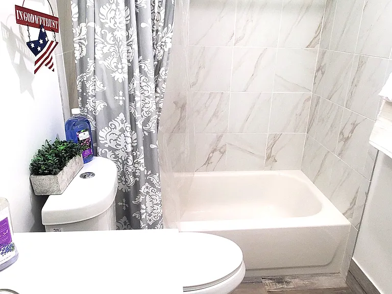 Sparkling clean full bathroom with elegant tile flooring. Features a dual-entry design_accessible from both the master bedroom and the hallway for maximum convenience.