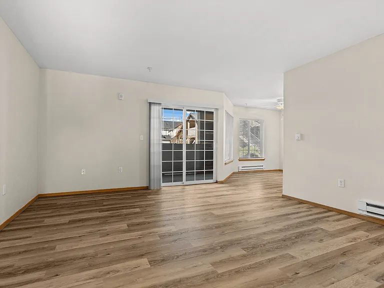 Open-concept living area with wood-style flooring and private patio access_designed for comfortable living in Tacoma, WA. Open-concept living area with wood-style flooring and private patio access_designed for comfortable living in Tacoma, WA.