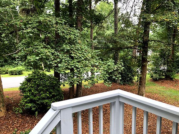 Front porch view of wooded front yard.