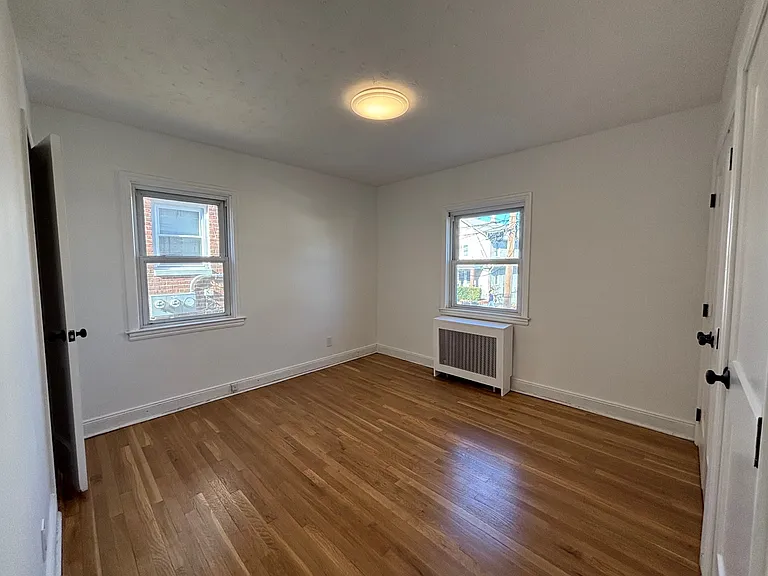 Bedroom 1 with 3 closets and refinished wood floor.