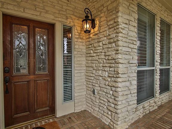 Note the stonework and the leaded glass front doors and carriage style lanterns.