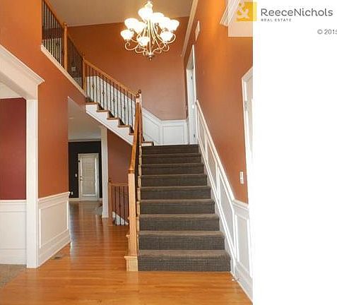 Soaring 2 story entry with iron spindled newly carpeted staircase.