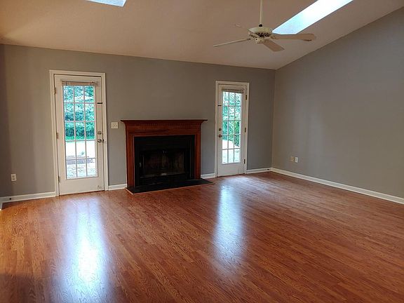 Living area with wood burning fireplace and skylights