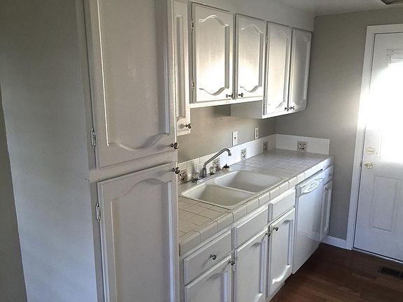 Galley kitchen with white cabinets