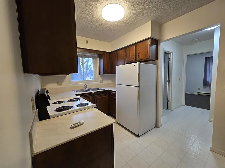 Kitchen toward hallway that leads to bathroom and bedroom
