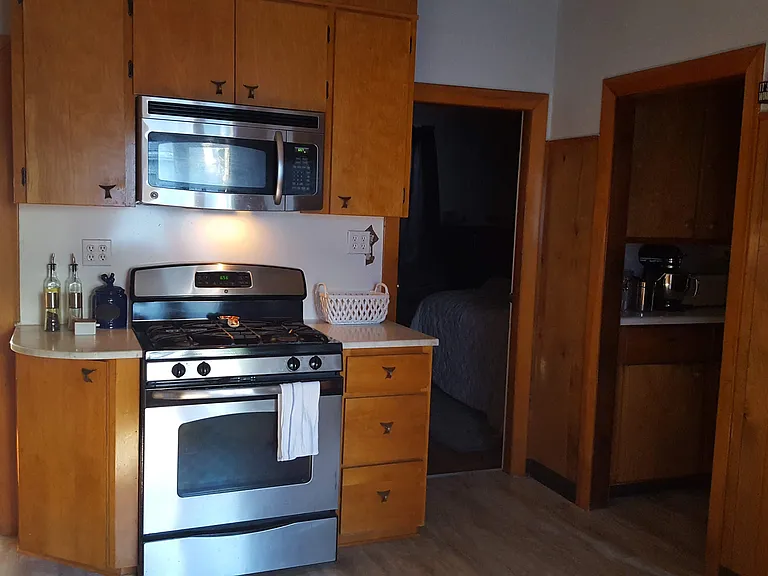 Kitchen area; to the left of stove is bedroom 2, to the right of stove is bedroom 1; pantry on far right