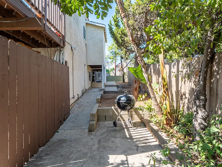 Side walkway to front and back houses, garden beds ready for planting