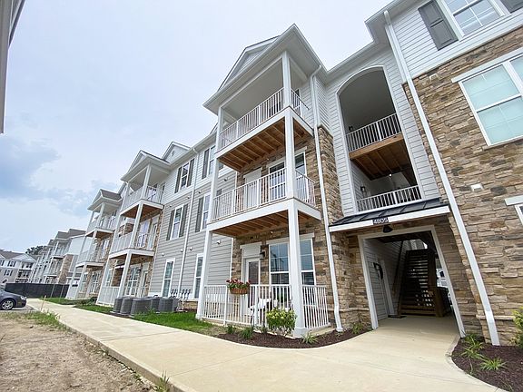 Three-story buildings with arched stairwells and private outdoor space create a clean, modern backdrop for everyday living.