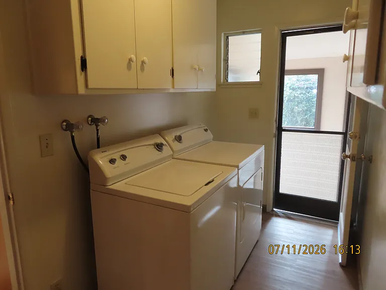 Laundry room with storage cabinets washer and dryer.