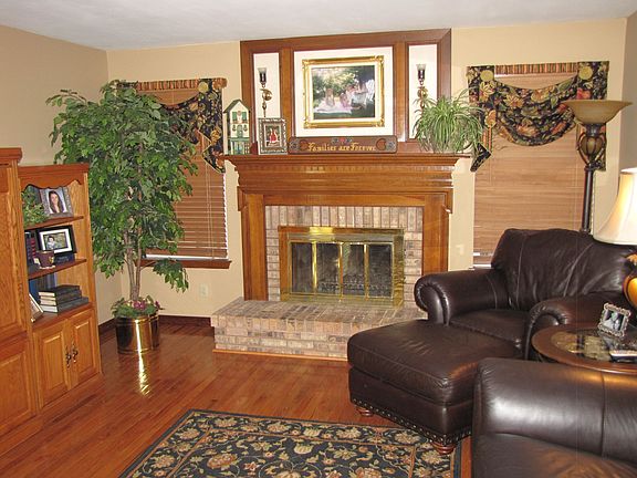 Rich wood floors and wood burning fireplace in the cozy family room