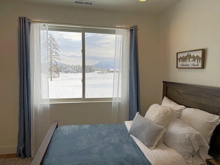 Inviting second-floor bedroom featuring peaceful mountain views and a warm Montana-inspired atmosphere.