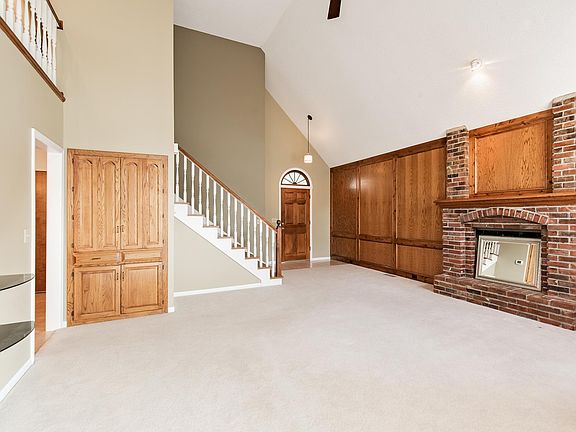 Living room with fireplace and hidden wet bar. Vaulted ceiling.