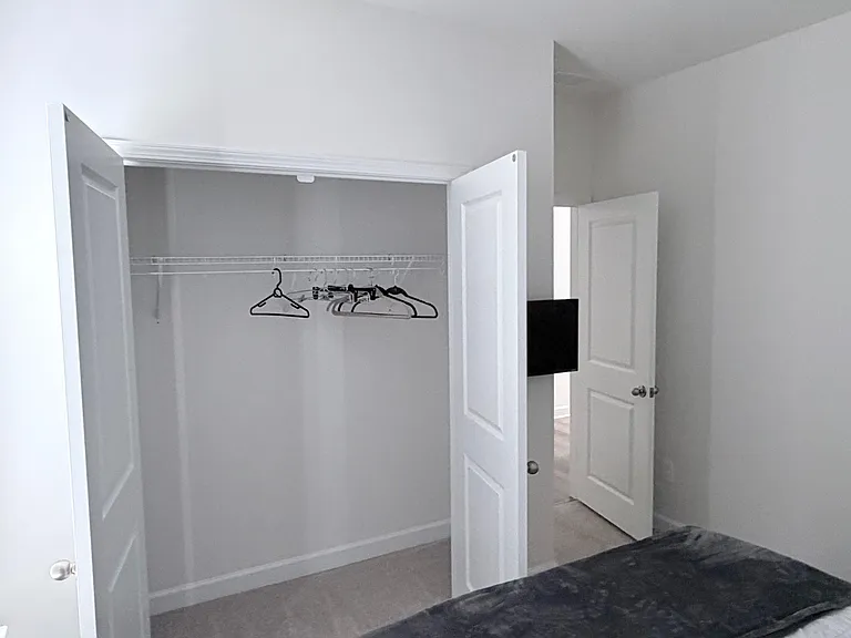 Bedroom offers a reach-in closet with double doors and a shelf-and-rod system for easy clothing storage.