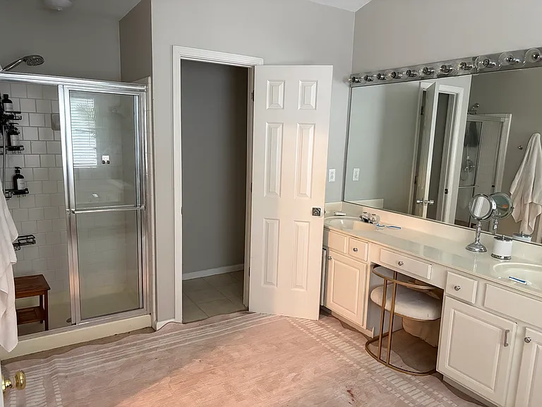Spacious spa-style primary bathroom featuring dual vanities, oversized mirrors, soaking tub, separate shower, and a bright, calming layout designed for everyday comfort.