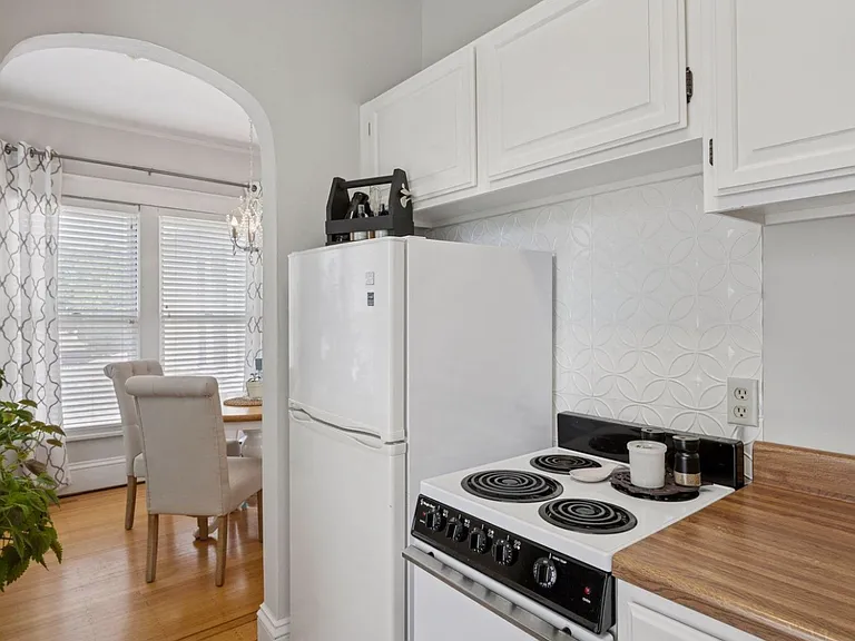 A second view of the kitchen, showing off the stovetop/oven, fridge, and even more storage. Comfy, but extremely functional kitchen space.