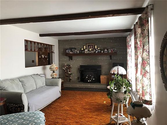 Living Room 20x11 Wood beam detail on ceiling. Working stone fireplace with wood mantle and stone hearth includes an insert to c