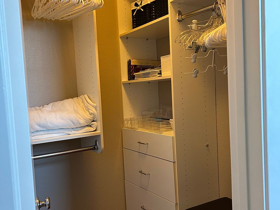 Top level Master bedroom walk in closet with hangers and storage bins