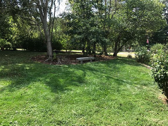 Front yard with stone bench.
