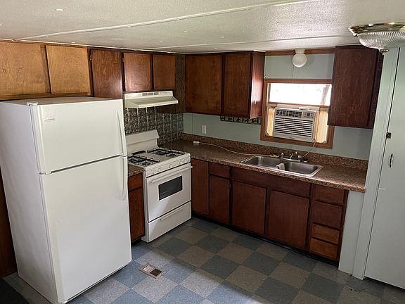 Gas stove w/range hood and fridge.