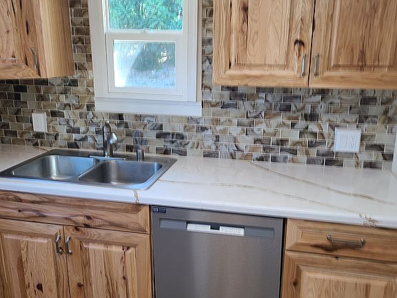Quartz countertop, double sink, dishwasher, garbage disposal, and custom cabinets - angle 2