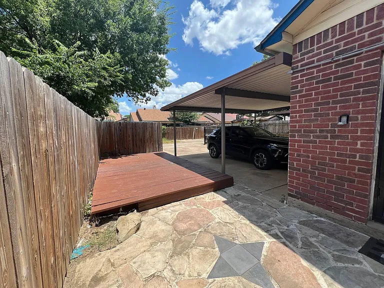 Raised patio deck next to carport.