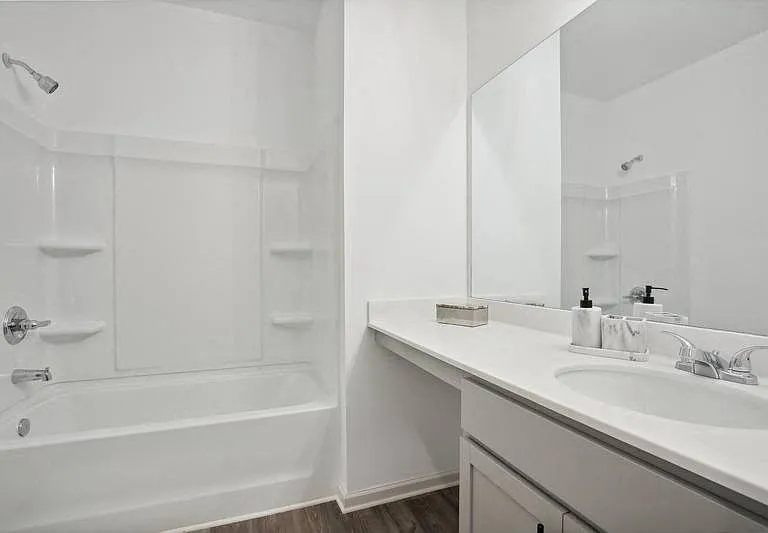 Secondary bathroom with tub shower and single vanity.