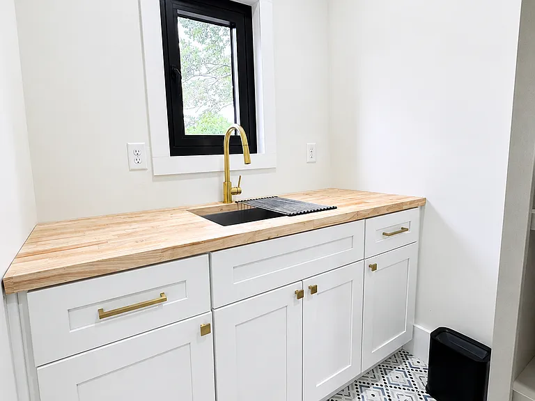 Laundry room with washer, dryer, sink, stocked essentials, and storage for convenient longer stays.