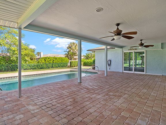 Private fenced backyard features huge under-truss lanai, pool, firepit and mature landscaping.