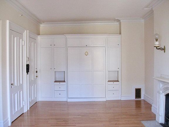 Living room with optional Murphy bed, hardwood floors, and fireplace. Murphy bed enables you to use the studio apartment WITHOUT having your bed visible in the room.