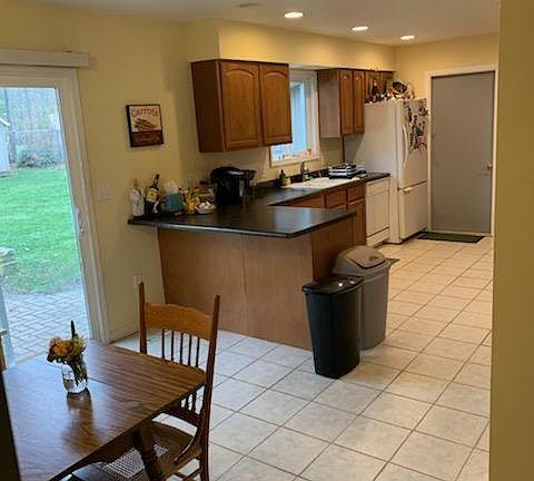 Eat-in kitchen has access to garage, brick patio & fenced backyard