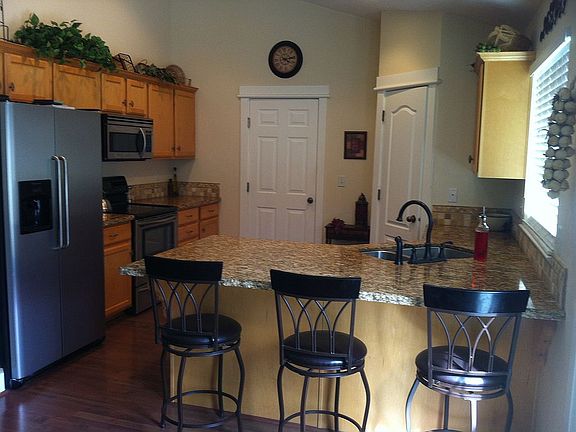 KItchen with stainless steel appliances, bar and pantry